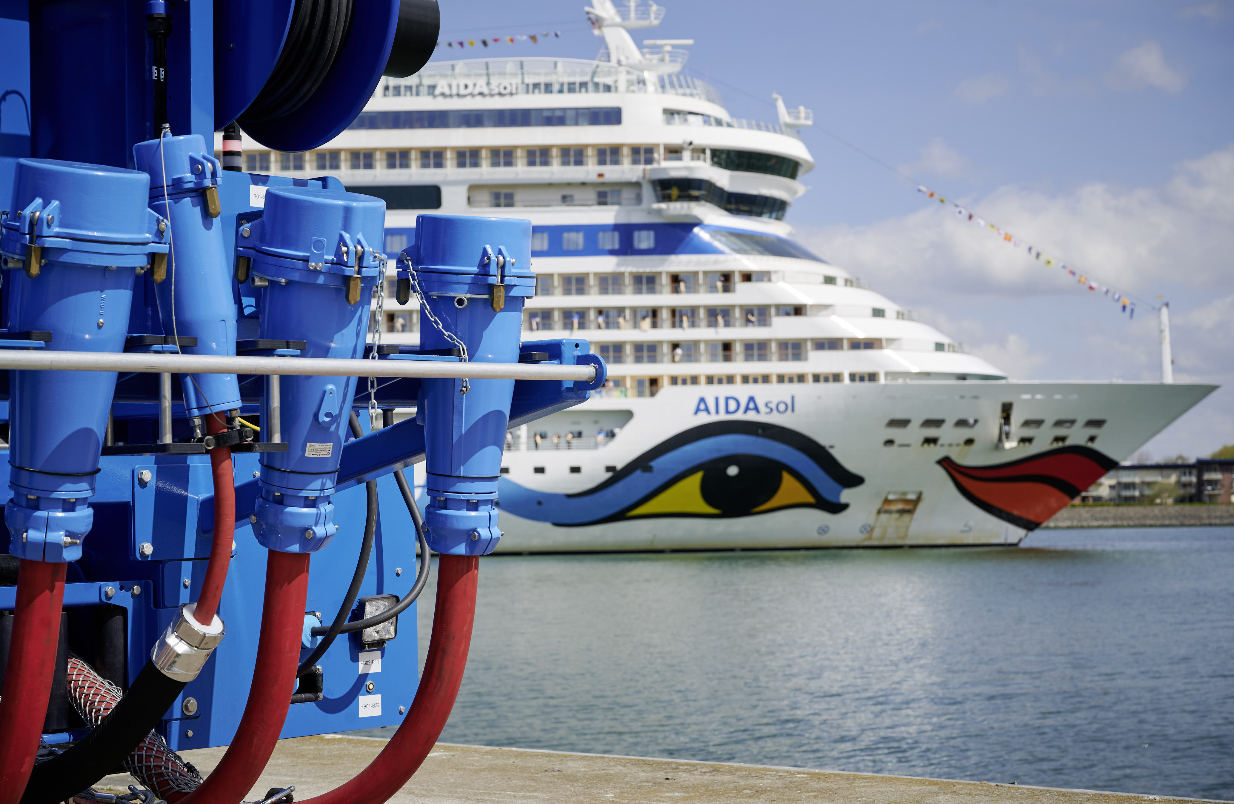 Kreuzfahrthafen Warnemünde. Detailfoto vom Landstromwagen und im Hintergrund ein Kreuzfahrtschiff auf der Warnow