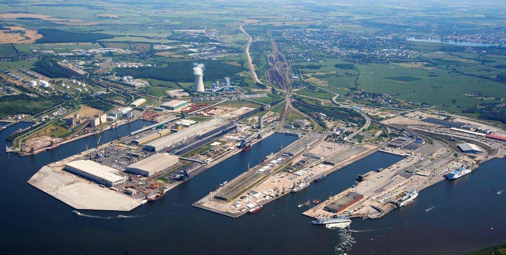 Luftaufnahme des Überseehafens Rostock mit Kaianlagen, Industrie- und Logistikflächen sowie Schiffen im Hafenbecken.