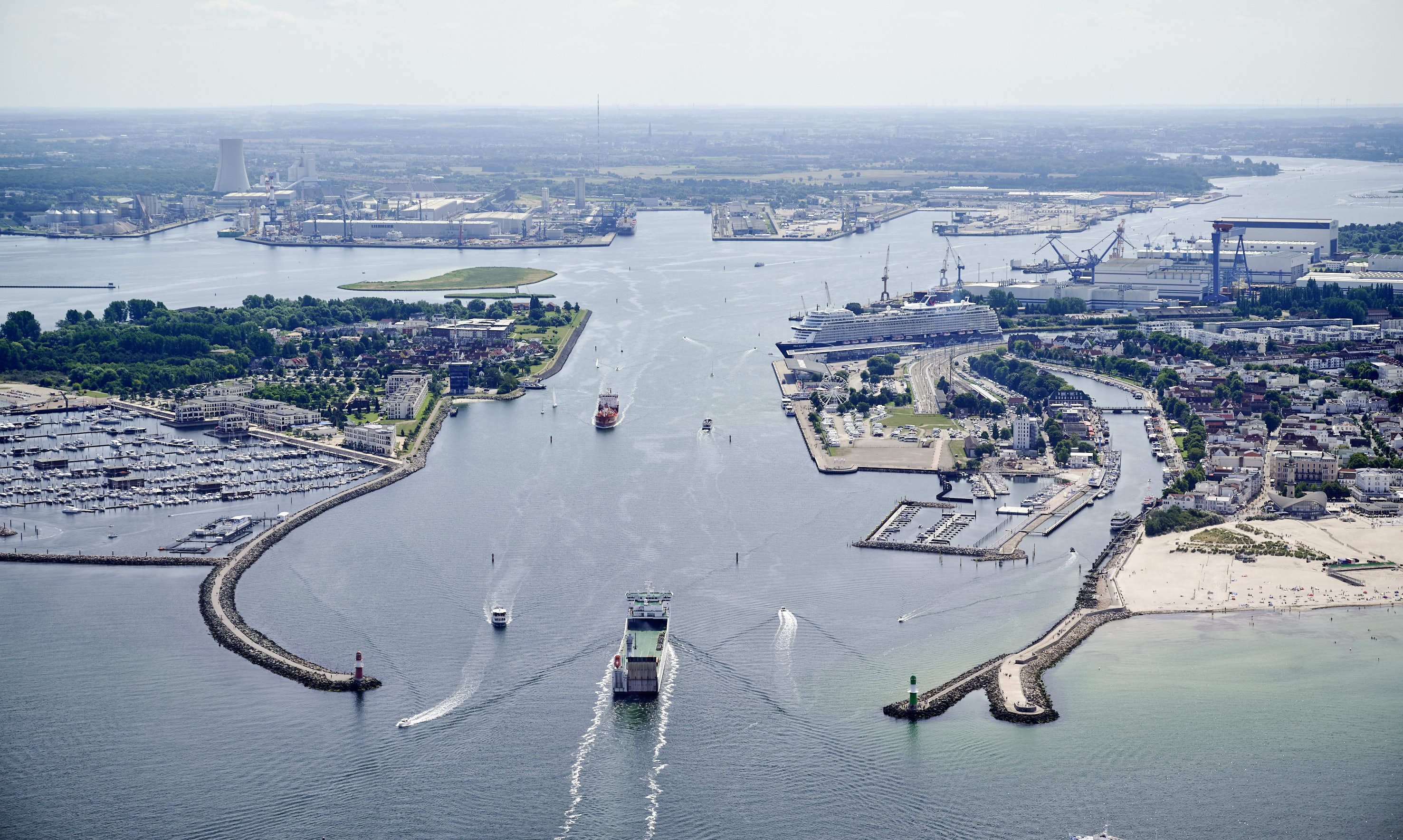 Luftaufnahme der Molenköpfe in Warnemünde. Ein Kreuzfahrtschiff zwischen den Molenköpfen in Warnemünde. Im Hintergrund ist der Rostocker Seehafen zu sehen.